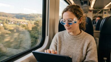 A young woman wearing liquid-filled motion sickness glasses while looking at a tablet during a car ride.